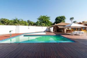 a swimming pool on a patio with a house at Chácara Luxuosa em Goiânia UPR0011 in Goiânia