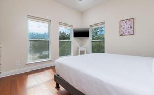 Un dormitorio con una cama grande y dos ventanas. en Pelican Roost 9407 home, en Gulf Highlands 35 fotos más