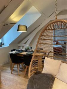 une salle à manger avec une table et une chaise en rotin dans l'établissement LE COCON : 2 chambres - Centre-ville, à Bourges