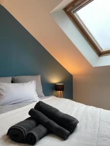 - un lit avec 3 serviettes dans l'établissement LE COCON : 2 chambres - Centre-ville, à Bourges