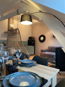 - une table à manger avec des assiettes bleues et des verres à vin dans l'établissement LE COCON : 2 chambres - Centre-ville, à Bourges