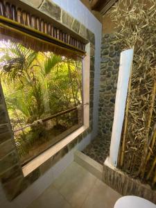 a bathroom with a window with a palm tree outside at Hotel Campestre mirador CaloPala in Machetá