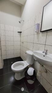 a bathroom with a white toilet and a sink at Hospedaje Vista Paraíso in Tingo María