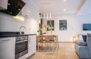 a kitchen and living room with a table and a couch at Apartamenty na Wyspie - Stella Baltic - Parking in Świnoujście