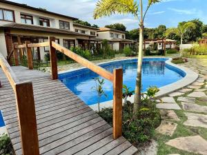 a wooden walkway leading to a swimming pool in a house at Luxuoso Apto na Villa de BG. in Marau