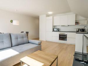 a living room with a couch and a kitchen at Ferienwohnung Weissach in Weissach