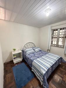 a bedroom with a bed with a blue comforter at Casa Astral a melhor escolha em ITAJAÍ in Itajaí
