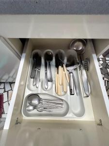 a drawer filled with silver utensils in a cabinet at Casa Astral a melhor escolha em ITAJAÍ in Itajaí