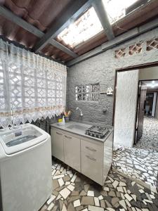 uma cozinha com um lavatório e um fogão em Casa Astral a melhor escolha em ITAJAÍ em Itajaí