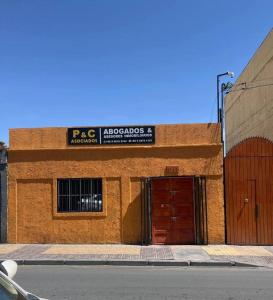 a brick building with a garage and a sign on it at Residencial Oasis Container in Calama