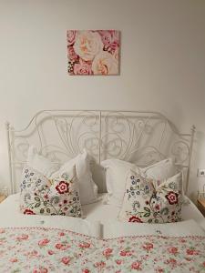 a bedroom with a white bed with floral pillows at Ferienwohnung Karasek Deluxe in Sattendorf