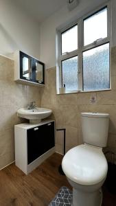a bathroom with a white toilet and a sink at Willesden Guest Room 130 in London