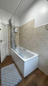 a white bath tub in a bathroom with a shower at Willesden Guest Room 130 in London