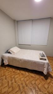 - une chambre avec un lit aux murs blancs et du parquet dans l'établissement Alojamiento Orejuelas #204, à Lima
