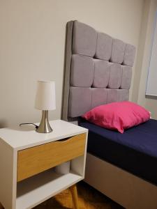 a bedroom with a bed with a pink pillow and a nightstand at Alojamiento Orejuelas #204 in Lima