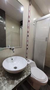 La salle de bains est pourvue d'un lavabo blanc et de toilettes. dans l'établissement Alojamiento Orejuelas #204, à Lima