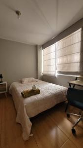 a bedroom with a bed with a window and a chair at Alojamiento Orejuelas #204 in Lima