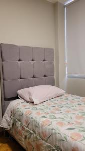 - un lit avec une tête de lit grise dans l'établissement Alojamiento Orejuelas #204, à Lima