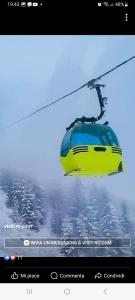 a yellow and blue train on a ski lift at Casa Roman in Statiunea Borsa