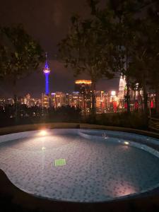 a swimming pool with a view of the city at night at Robertson by Shahjalal Suites in Kuala Lumpur