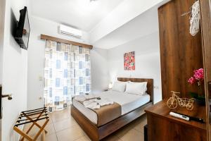 um quarto com uma cama, uma televisão e uma janela em Stelios & Stavros Apartment em Kissamos