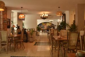 ein Restaurant mit Tischen und Stühlen und einem Gemälde an der Wand in der Unterkunft Hotel Kartaxa in Cartagena de Indias