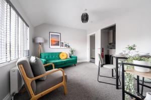 a living room with a green couch and a table at William Street Apartment in Cleethorpes +18 photos