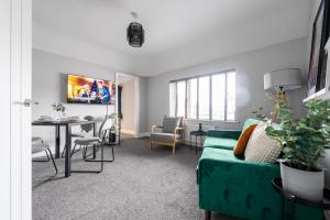a living room with a green couch and a table at William Street Apartment in Cleethorpes