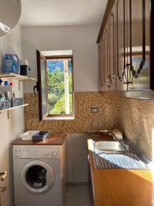 a kitchen with a washing machine and a sink at 4 Seasons Apartment in Leskovik +14 photos