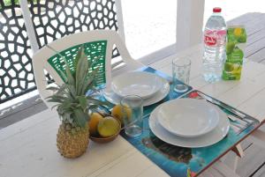 a table with two plates and a pineapple on it at La Dicossine - La Guadeloupe au naturel ;) in Les Abymes