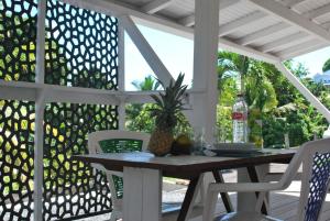 a table and chairs on a patio with a fence at La Dicossine - La Guadeloupe au naturel ;) in Les Abymes