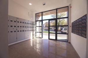 an empty hallway with a door open to a room with lockers at Apartman MRL Cavic in Banja Luka