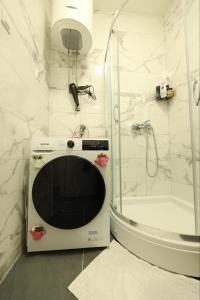 a microwave in the corner of a bathroom with a shower at Apartman MRL Cavic in Banja Luka