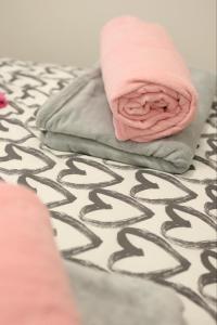 a pink rose sitting on top of a bed at Apartman MRL Cavic in Banja Luka