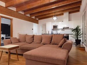 a living room with a couch and a kitchen at BeeHome Apartment in Purkersdorf