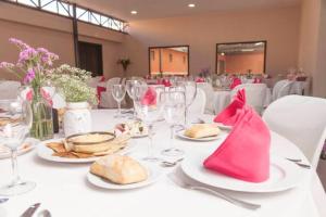 a white table with plates of food and wine glasses at Finca para eventos y complejo rural Mi Cobijo in Fuentelviejo
