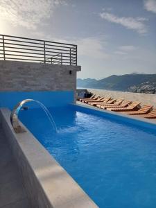 多布拉沃達的住宿－Bosfor Hotel，一个带椅子的蓝色游泳池和一个喷泉
