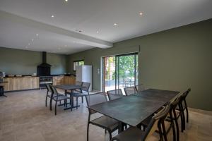 une cuisine et une salle à manger avec des tables et des chaises dans l'établissement Le domaine du Pech Eternel, à Sarlat-la-Canéda