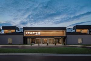 a building with a court yardarma sign on the front at Courtyard by Marriott Greensboro in Greensboro