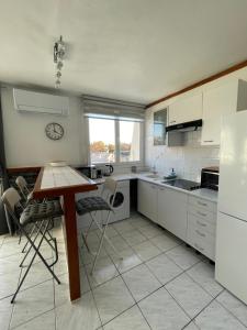 uma cozinha com electrodomésticos brancos e uma mesa e cadeiras em Vintage Port Marianne Montpellier em Montpellier