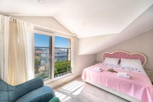 厄吕代尼兹Stunning Suite in Ölüdeniz with Seaview And Pool的卧室配有粉红色的床和椅子 更多37张照片