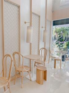 a dining room with tables and chairs and a window at Nama Hostel Chiangmai in Chiang Mai