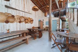 a room with wooden tables and chairs in a building at Casa da Esquina Caraíva in Caraíva
