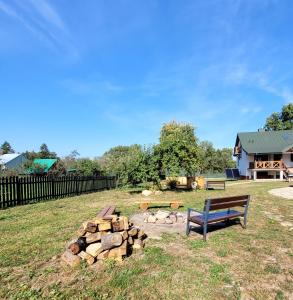 ławka w parku siedząca obok stosu drewna opałowego w obiekcie Kasztanówka - dom gościnny na Podlasiu, agroturystyka w mieście Szepietowo