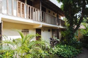 a building with a balcony on the side of it at Casa da Esquina Caraíva in Caraíva