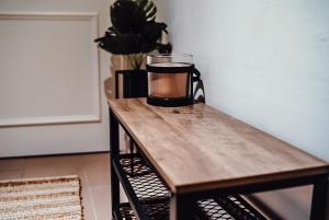 a coffee mug on a wooden table with a plant at Fewostaeps- Moderne Unterkunft, zentrumsnah in Plauen