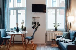 uma sala de estar com uma mesa e cadeiras e um sofá em Fewostaeps- Moderne Unterkunft, zentrumsnah em Plauen