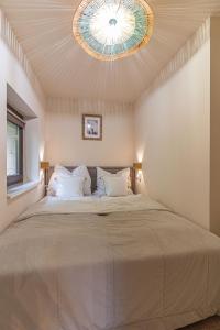 a bedroom with a large bed with a ceiling at HeLo Bungalow in Badacsonytördemic