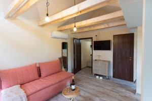 a living room with a pink couch and a tv at HeLo Bungalow in Badacsonytördemic