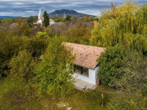 a small white house in the middle of trees at HeLo Bungalow in Badacsonytördemic
